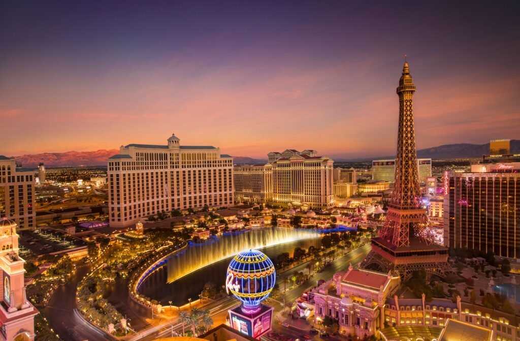 Stunning aerial view of Las Vegas skyline at sunset, featuring the Eiffel Tower and Bellagio fountains.